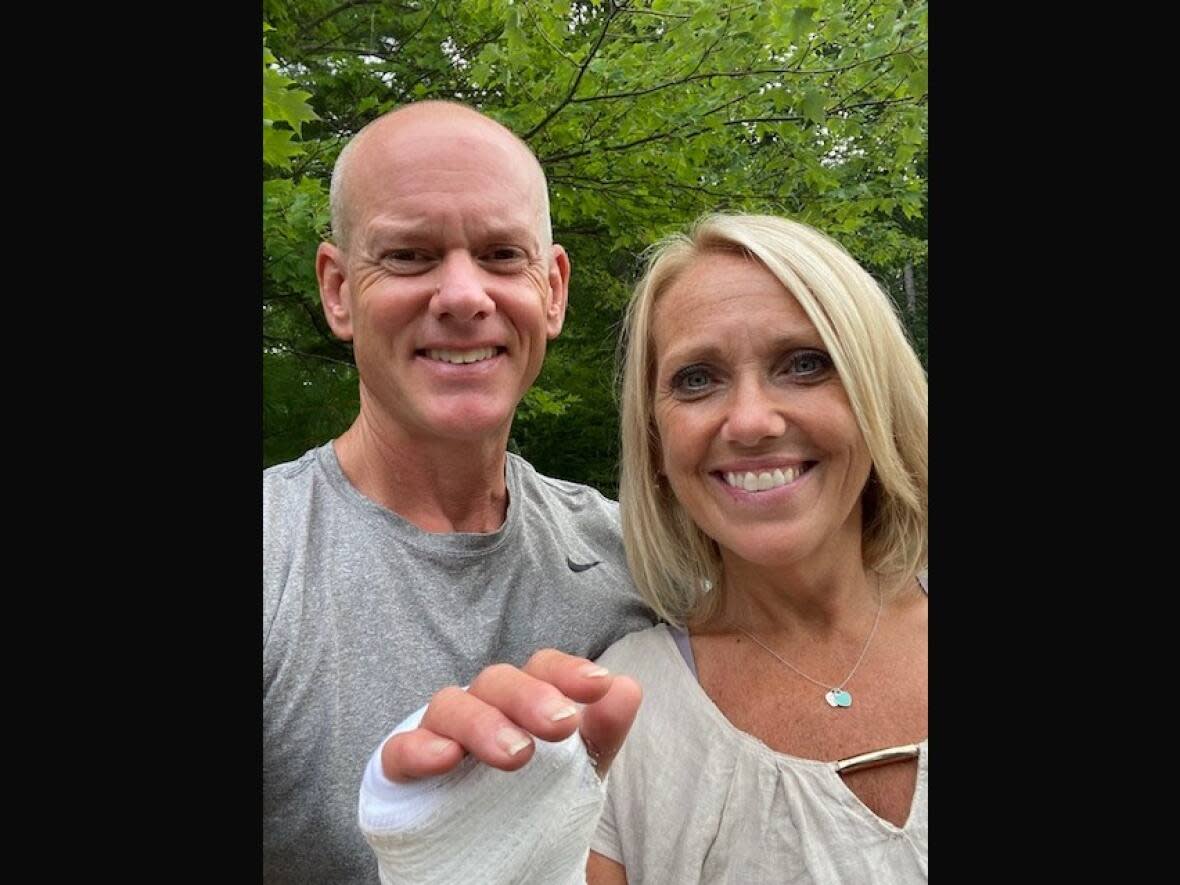 Andrew and Lisa MacAdam of Conquerall Mills, N.S., are shown with Lisa's bandaged wrist that was broken in a fall last weekend near Big Intervale, Cape Breton. (Submitted by Andrew MacAdam - image credit)