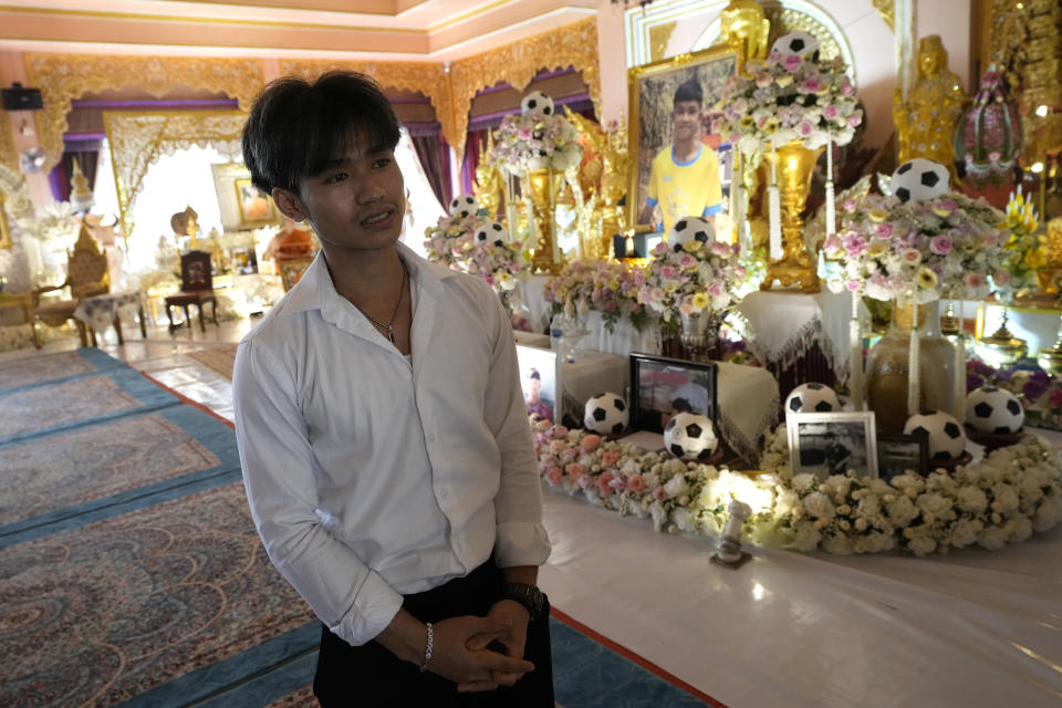 Adul Sam-on, a member of the Wild Boars soccer team rescued from a flooded cave 2018, talks to a reporter in front of the ashes of late Duangphet Phromthep at Wat Phra That Doi Wao temple in Chiang Rai province Thailand, Monday, March 6, 2023. The ashes of Duangphet Phromthep in a makeshift boat were scattered into the Mekong River Monday. (AP Photo/Sakchai Lalit)