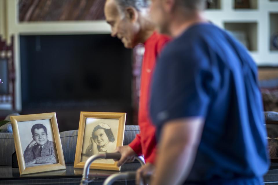 Robert Borns exercises in a living room filled with family photos