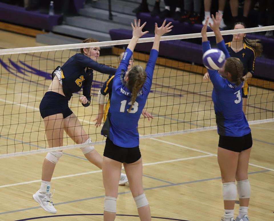 Notre Dame’s Abby Korschgen (23) spikes the ball against Holy Trinity’s Mary Kate Bendlage (13) and Kayla Box (3) in a Class 1A regional final Wednesdayin Burlington. Holy Trinity won the match, 3-1.