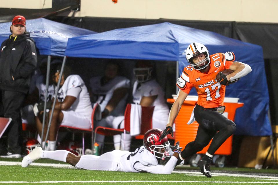 Cincinnati's Justin Harris tackles Oklahoma State's Leon Johnson III during the first half of an NCAA college football game Saturday, Oct. 28, 2023, in Stillwater, Okla. (AP Photo/Mitch Alcala)