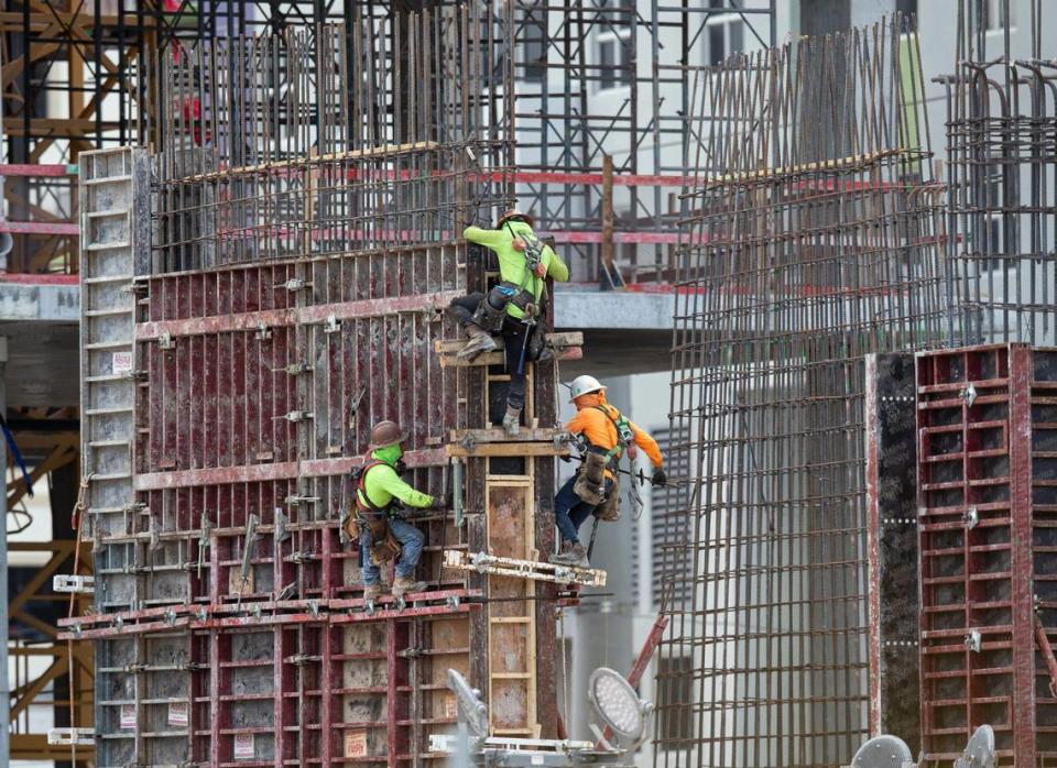 Construction workers labor at the construction site off South Dixie Highway and Southwest 37th Avenue in Coral Gables on Tuesday, March 31, 2020.