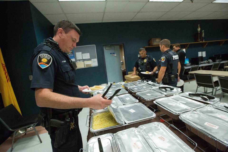 In this file photo from 2018, then Las Cruces Police Officer Pierce Wilber opens up trays of food donated by Olive Garden to LCPD on Labor Day, Monday Sept. 3, 2018. Wilber is now a detective.