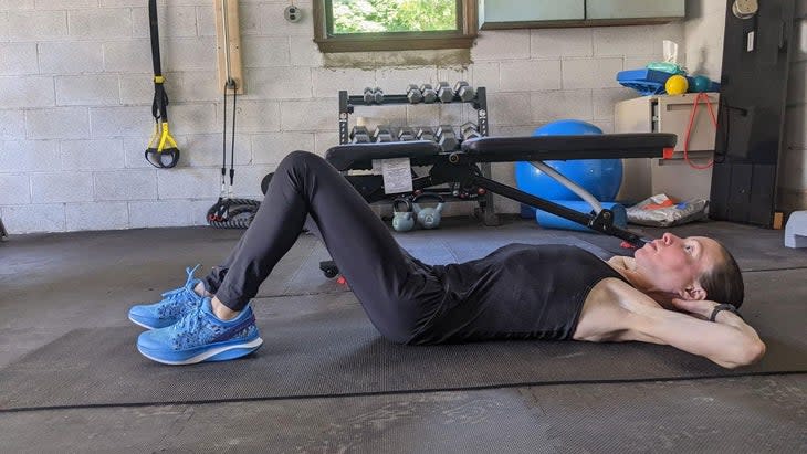 Woman demonstrates a sit up 