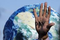 FILE - A hand reads "pay" calling for reparations for loss and damage at the COP27 U.N. Climate Summit, Friday, Nov. 18, 2022, in Sharm el-Sheikh, Egypt. (AP Photo/Peter Dejong, File)