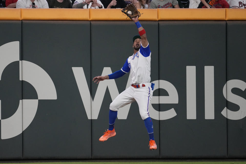 Atlanta Braves left fielder Eddie Rosario (8) makes a leaping catch on a line drive from Washington Nationals' Lane Thomas (28) in the seventh inning of a baseball game, Saturday, Sept. 30, 2023, in Atlanta. (AP Photo/John Bazemore)