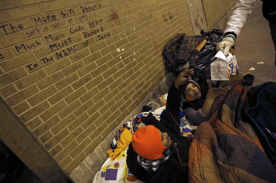 Doctor Angelo hands out food to homeless people under the overpasses on Lower Wacker Drive in Chicago
