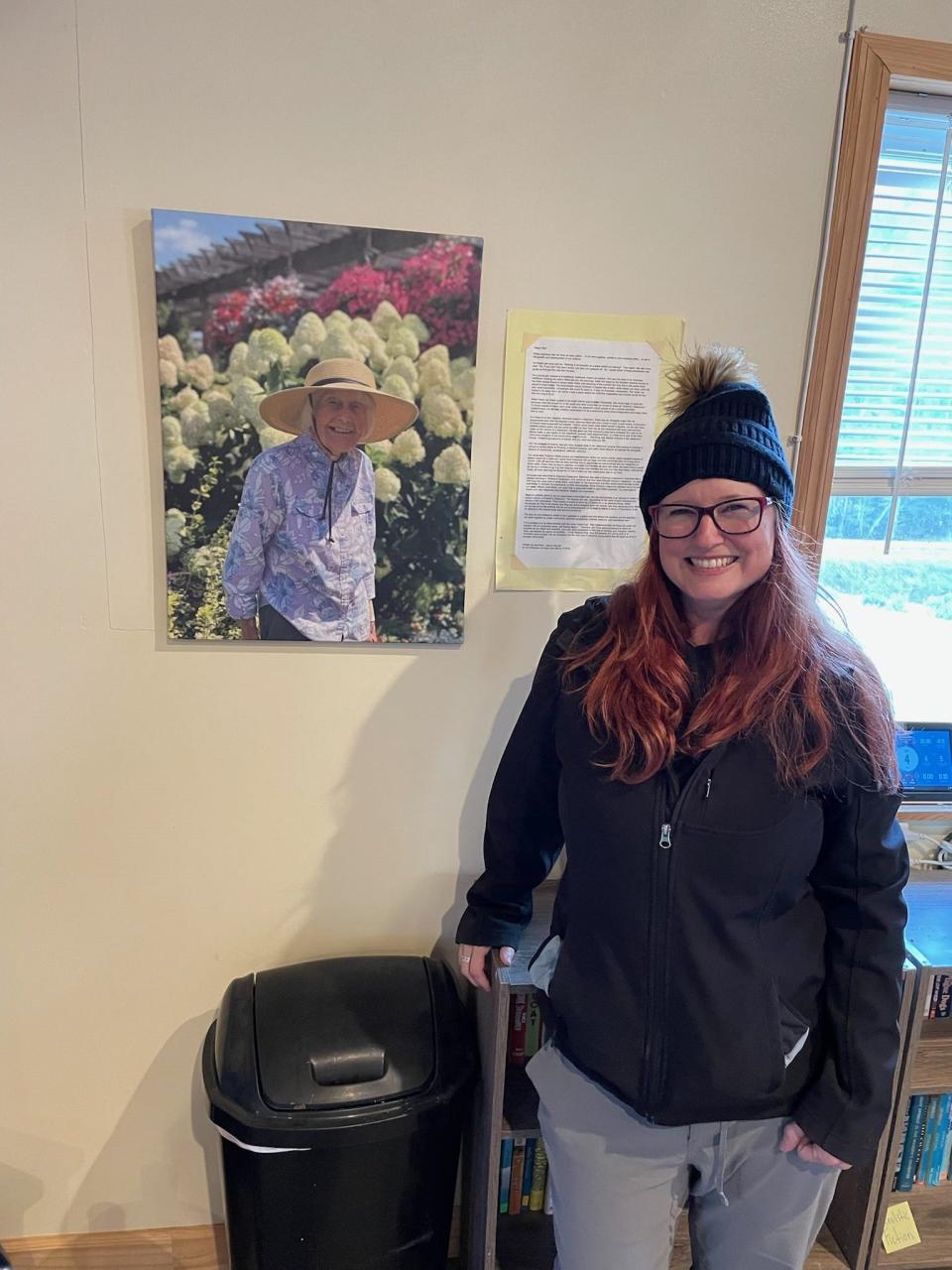 Woodson Branch Nature School Executive Director poses in Hazel Lee Hall in front of a photo of her grandmother, for whom the building is named.