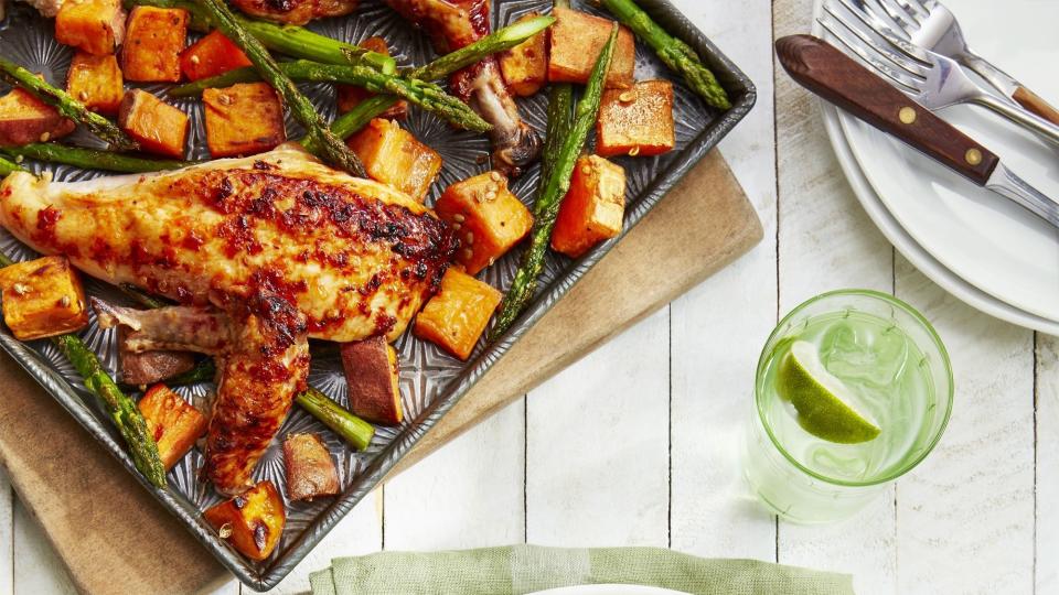 sweet and spicy chicken with roasted sweet potatoes and asparagus on a white plate with silverware