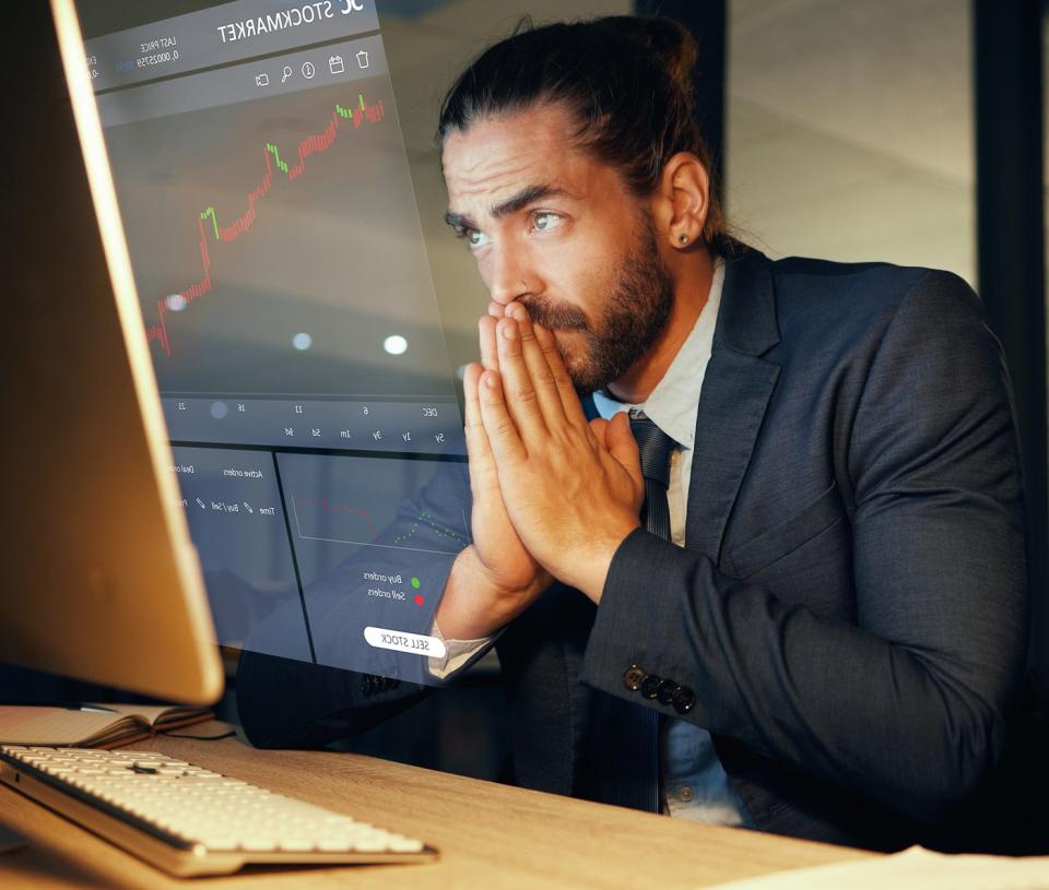 Nervous investors look at stock charts on their computers.