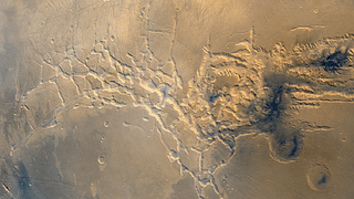 Noctis Labyrinthus, whose eastern end hides a heavily eroded giant volcano. - Image: <a class="link " href="https://nssdc.gsfc.nasa.gov/imgcat/html/object_page/vo1_mg01n104.html" rel="nofollow noopener" target="_blank" data-ylk="slk:NASA;elm:context_link;itc:0;sec:content-canvas">NASA</a>