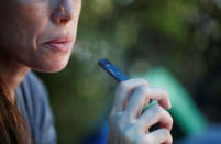 A woman smokes a Juul e-cigarette in this posed picture, near Jerusalem September 16, 2018. REUTERS/Ronen Zvulun