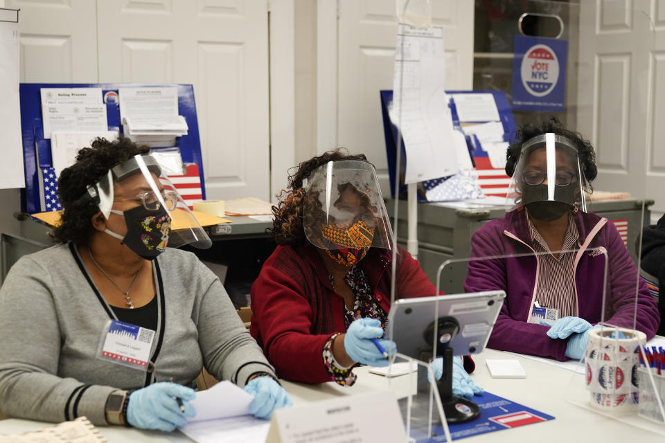 Election workers prepare to register voters on Election Day at a polling place inside the Bartow Community Center, Tuesday, Nov. 3, 2020, in the Bronx borough of New York. (AP Photo/Mark Lennihan)