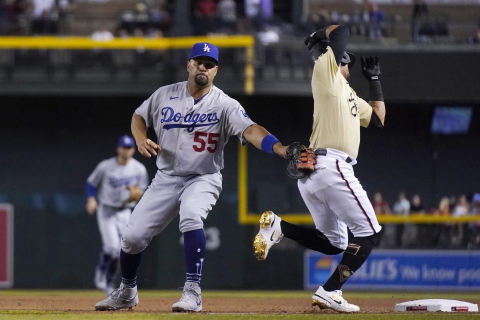 Los Angeles Dodgers first baseman Albert Pujols (55) tags out Arizona Diamondbacks' Ildemaro Vargas as a wide throw took Pujols off the base during the seventh inning of a baseball game Friday, June 18, 2021, in Phoenix. (AP Photo/Ross D. Franklin)