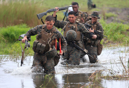 U.S. military forces cross a flooded area near the shore during the annual Philippines-US amphibious landing exercise (PHIBLEX) at San Antonio, Zambales province, Philippines October 7, 2016. REUTERS/Romeo Ranoco/File Photo