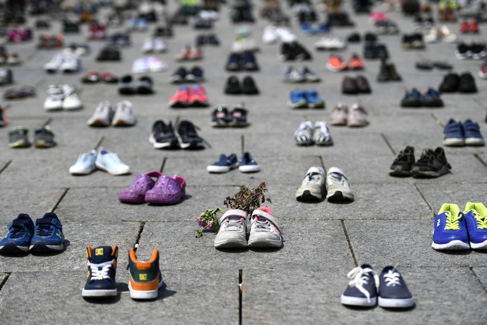 Dried flowers rest inside a pair of child's running shoes at a memorial for the 215 children whose remains were found at the grounds of the former Kamloops Indian Residential School at Tk'emlups te Secwépemc First Nation in Kamloops, B.C., on Parliament Hill in Ottawa on Friday, June 4, 2021. (Justin Tang/The Canadian Press via AP)