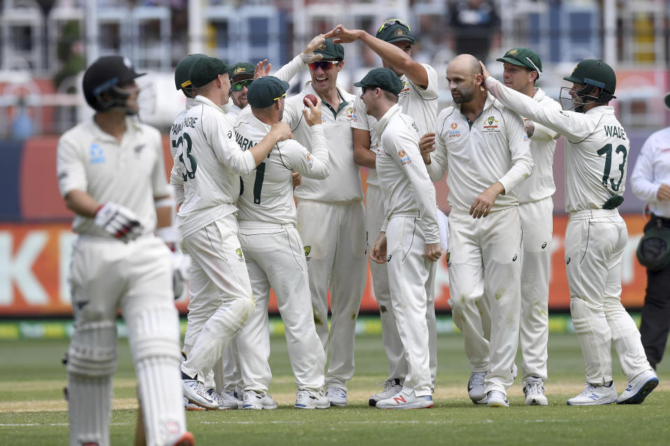 Australian players celebrate the wicket of New Zealand's Colin de Grandhomme, left, during play in their cricket test match in Melbourne, Australia, Sunday, Dec. 29, 2019. (AP Photo/Andy Brownbill)