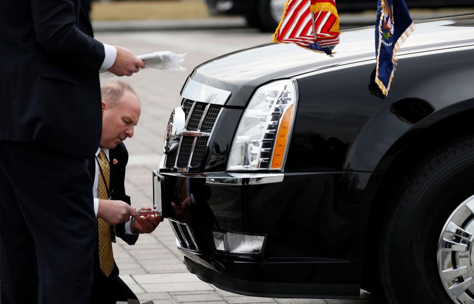 Secret Service agents change license plates on the presidential limousine