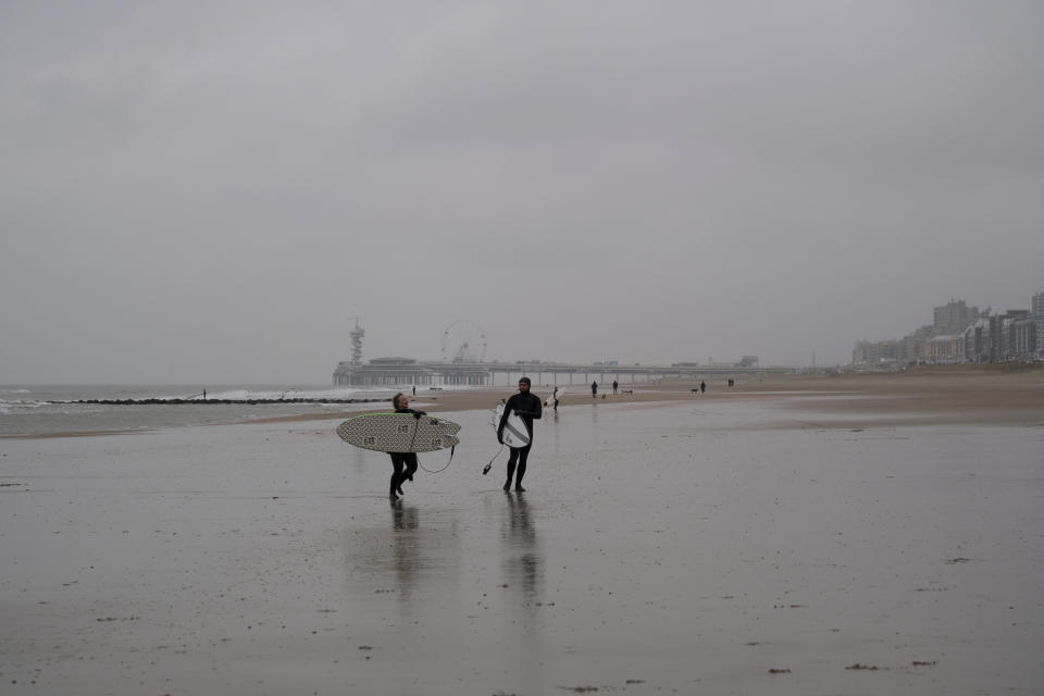Two surfers walk away from the North Sea as winds pick up speed ahead of the arrival of storm Eunice at Scheveningen, the Netherlands, on Friday Feb. 18, 2022. The Netherlands and other western European nations were bracing for the second powerful storm in three days. (AP PHOTO/Mike Corder)