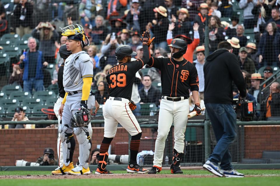 Giants infielder Thairo Estrada is greeted at home by teammate LaMonte Wade Jr.  after hitting a two-run homer against the Brewers in the third inning Saturday night.