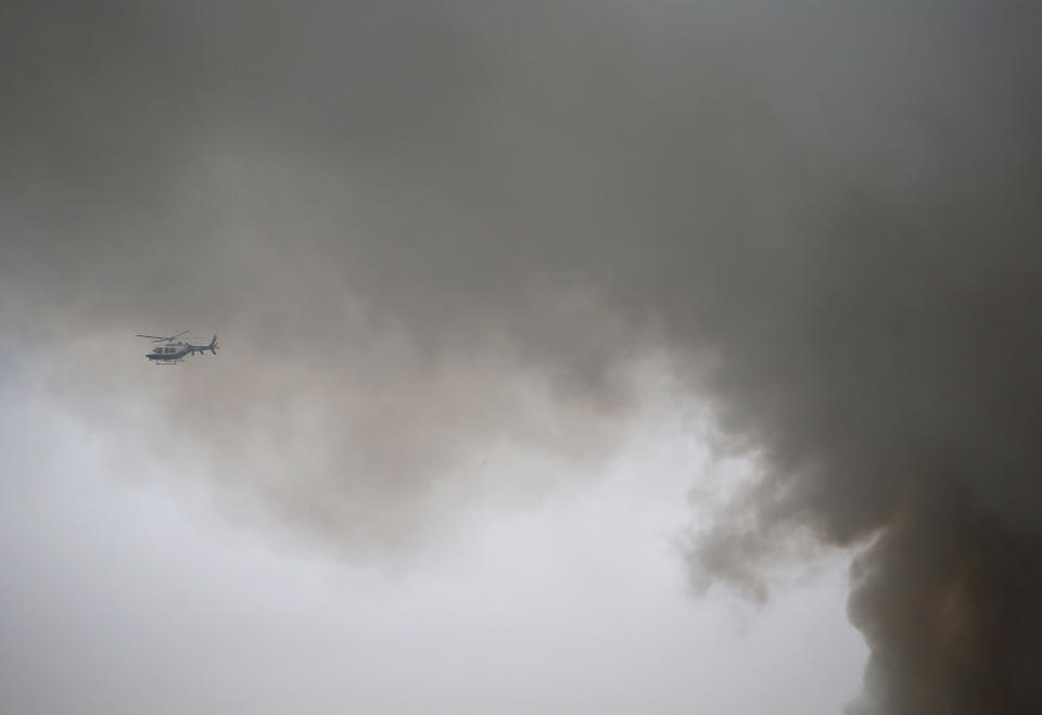 NEW YORK, NY - MARCH 26:  New York Police Department helicopter hovers as smoke rises from a burning building after an explosion on 2nd Avenue on March 26, 2015 in New York City. The seven alarm fire drew firefighters from across the city, with at least 12 injuries being reported. (Photo by John Moore/Getty Images)