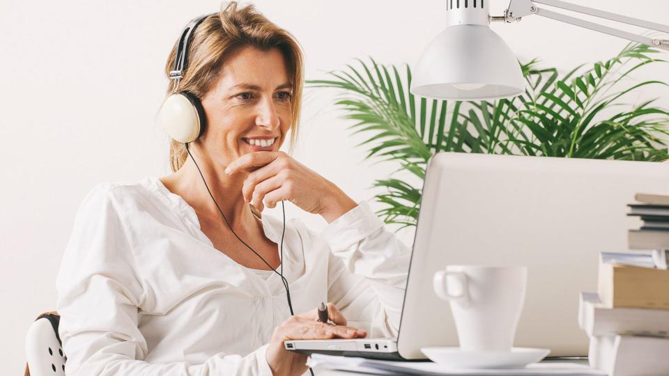 Smiling mature woman listening music with headphones.