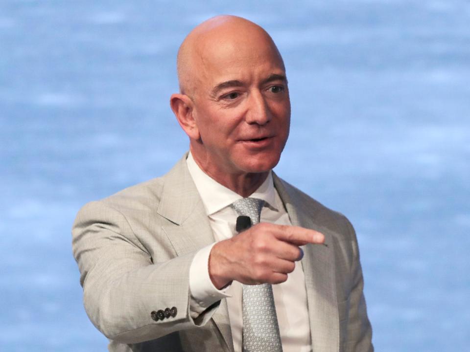 Jeff Bezos points and looks off camera onstage