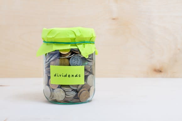 Jar of coins with yellow label that says dividends.