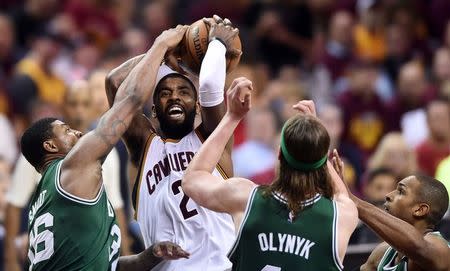 May 23, 2017; Cleveland, OH, USA; Cleveland Cavaliers guard Kyrie Irving (2) drives to the basket between Boston Celtics guard Marcus Smart (36) and center Kelly Olynyk (41) during the second half in game four of the Eastern conference finals of the NBA Playoffs at Quicken Loans Arena. Mandatory Credit: Ken Blaze-USA TODAY Sports