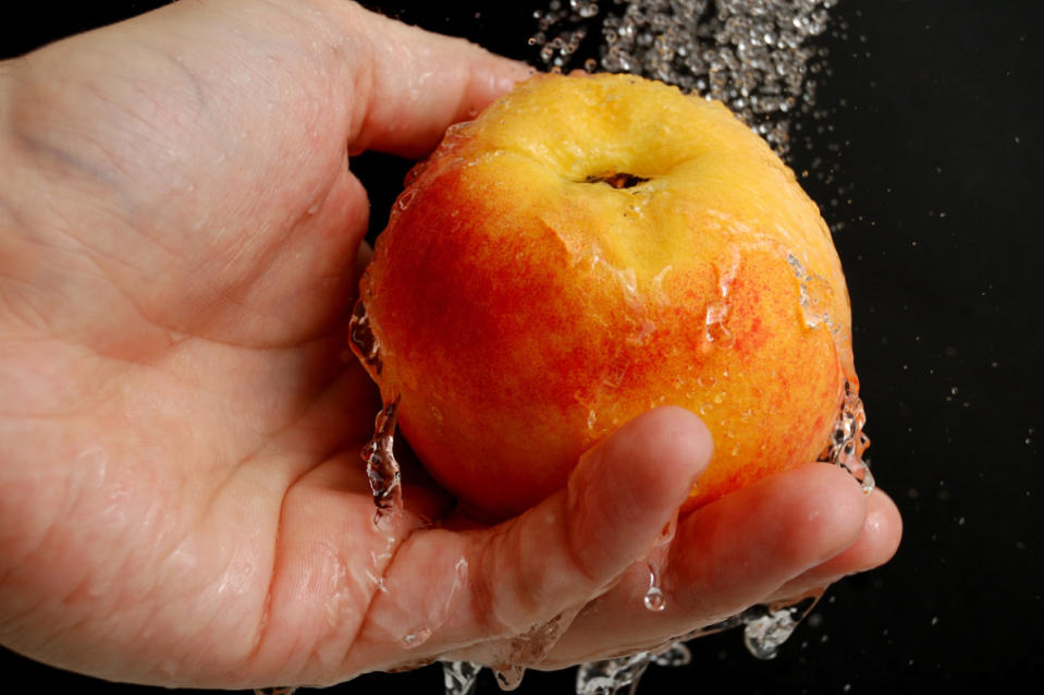 Washing a peach under water - hygiene<p>iStock</p>