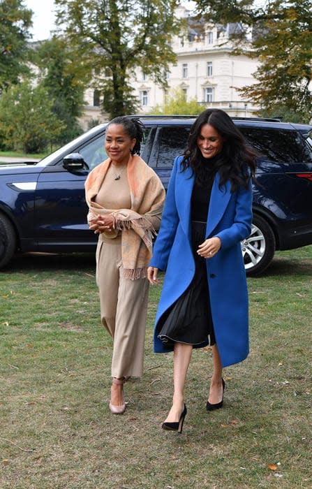 Meghan Markle and her mother, Doria Ragland, walking and smiling