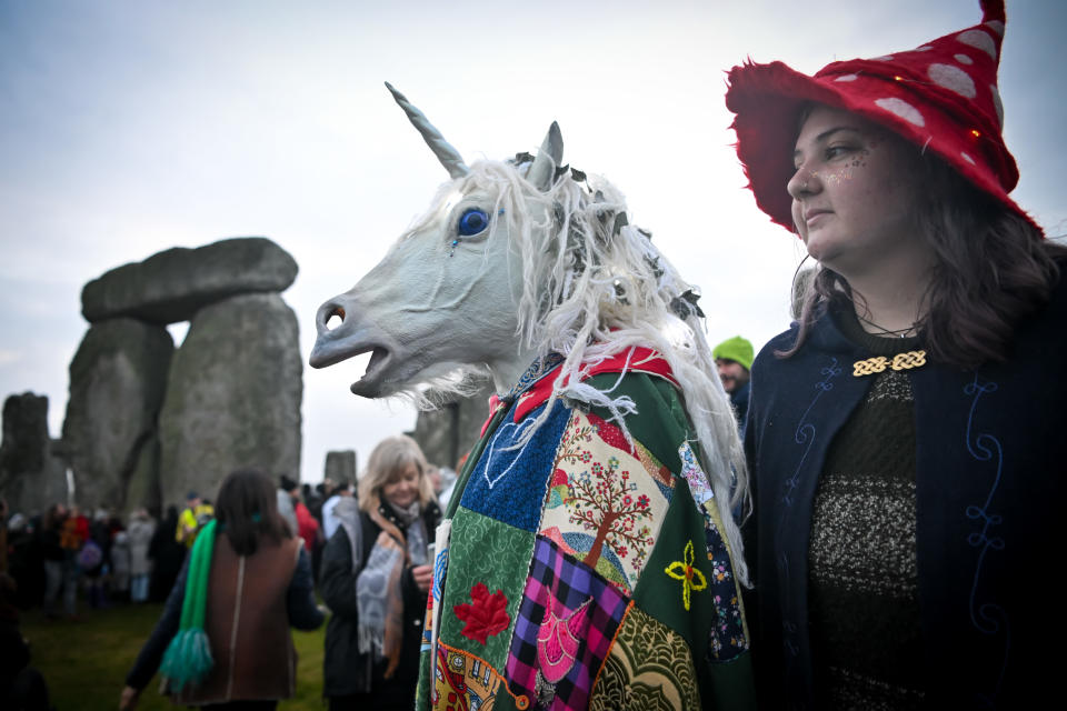 AMESBURY, ENGLAND - DECEMBER 22: A unicorn walks through Stonehenge as people greet the sunrise, on December 22, 2022, in Amesbury, United Kingdom. The famous historic stone circle, a UNESCO listed ancient monument and World Heritage Site, attracts visitors to celebrate the sunrise closest to the Winter Solstice, the shortest day of the year. The event is claimed to be more important in the pagan calendar than the summer solstice, because it marks the 're-birth' of the Sun for the New Year. (Photo by Finnbarr Webster/Getty Images)