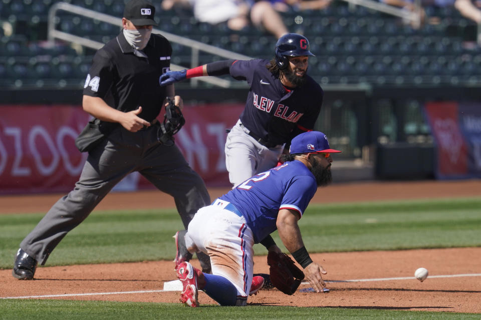 Texas Rangers third baseman Rougned Odor, front waits for the throw at third base on a triple by Cleveland Indians' Billy Hamilton during the fourth inning of a spring training baseball game Tuesday, March 9, 2021, in Surprise, Ariz. (AP Photo/Sue Ogrocki)