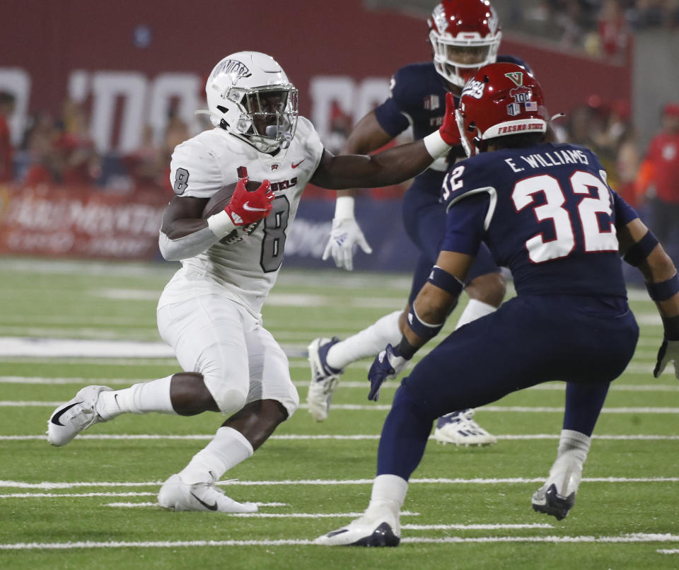UNLV running back Charles Williams looks to run past Fresno State defensive back Evan Williams during the first half of an NCAA college football game in Fresno, Calif., Friday, Sept. 24, 2021. (AP Photo/Gary Kazanjian)