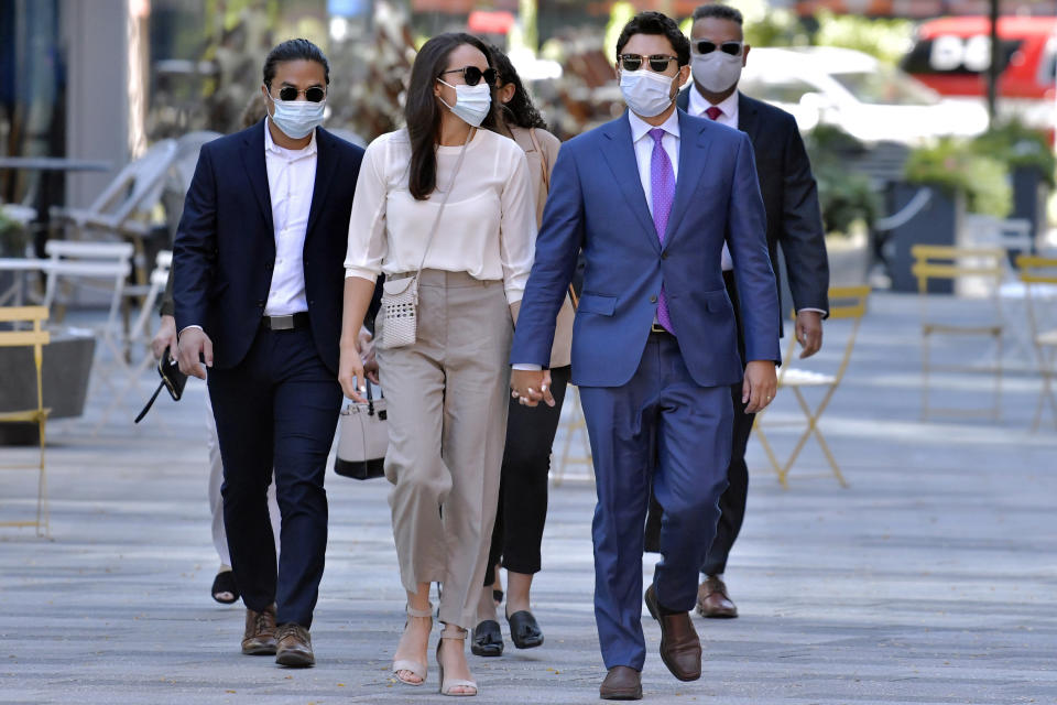 Former Fall River, Mass. Mayor Jasiel Correia, right, arrives with his wife and his wife Jenny Fernandes, center, and family members for a court appearance at the John Joseph Moakley United States Courthouse, Monday, Sept. 20, 2021, in Boston. Correia, who was elected at the age of 23 with promises to rejuvenate the struggling mill city, was scheduled to be sentenced for stealing from investors in a smartphone app he created and extorting hundreds of thousands of dollars in bribes from marijuana businesses. (AP Photo/Josh Reynolds)