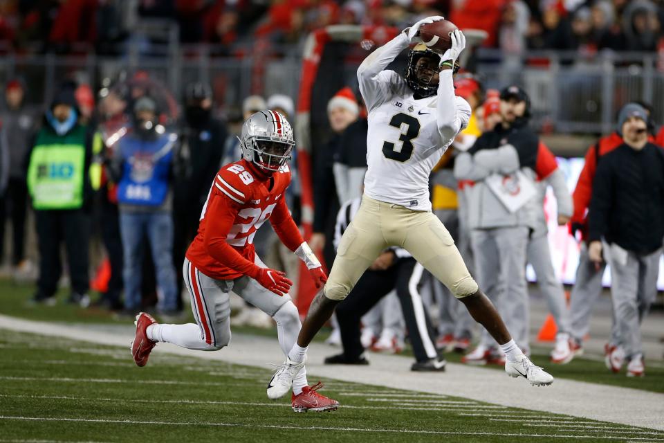 Purdue receiver David Bell, right, catches a pass in front of Ohio State defensive back Denzel Burke during the second half of an NCAA college football game Saturday, Nov. 13, 2021, in Columbus, Ohio. (AP Photo/Jay LaPrete)