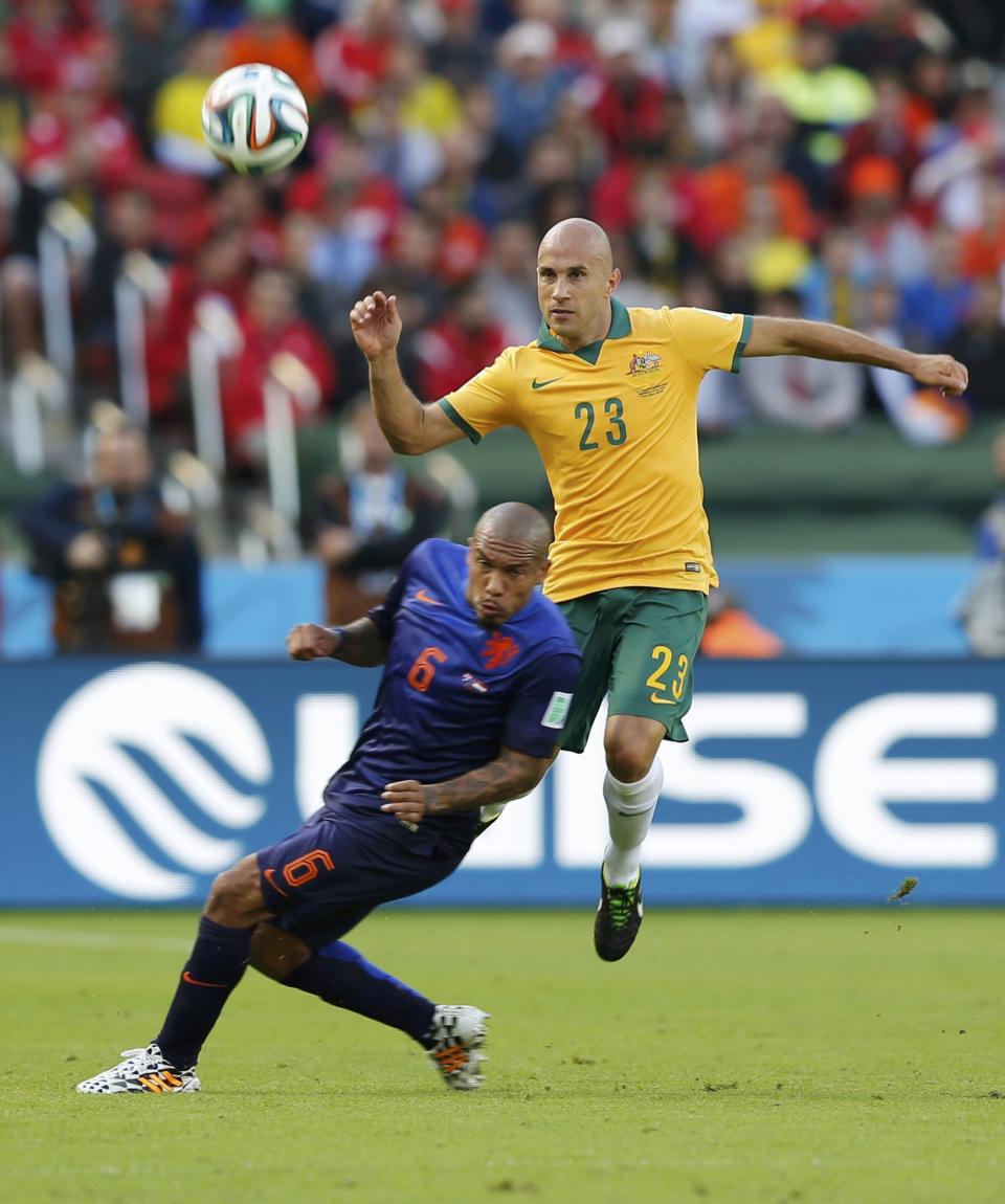 Australia's Mark Bresciano (R) fights for the ball with Nigel de Jong of the Netherlands during their 2014 World Cup Group B soccer match at the Beira Rio stadium in Porto Alegre June 18, 2014. REUTERS/Edgard Garrido (BRAZIL - Tags: SOCCER SPORT WORLD CUP)