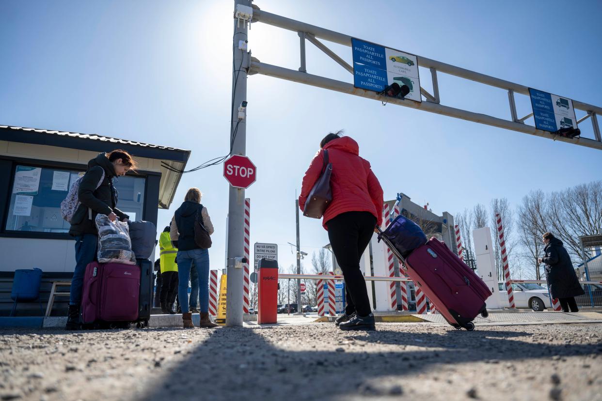 Valentina Garbetz, right center, and her family drag their belongings east back home to Ukraine at the Ukrainian-Moldovan border crossing in Palanca, Moldova on Tuesday, March 22, 2022.