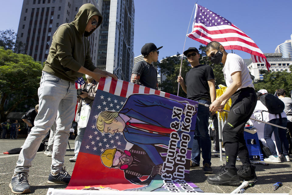 People prepare the flags during a rally in Hong Kong, Sunday, Dec. 1, 2019. China accused the U.N. high commissioner for human rights of emboldening "radical violence" in Hong Kong by suggesting the city's leader conduct an investigation into reports of excessive use of force by police. The back and forth came ahead of three marches on Sunday in the semi-autonomous Chinese territory. (AP Photo/Ng Han Guan)