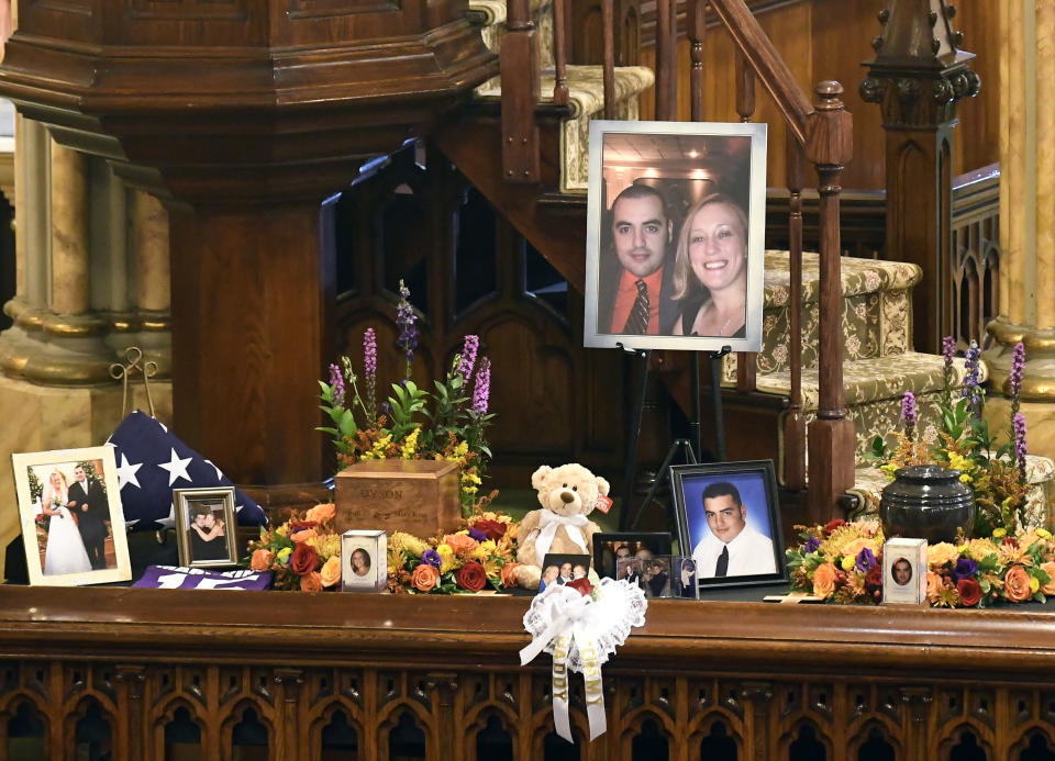 A unity urn with cremated ashes of Robert Joseph Dyson and Mary E. Dyson is set in place as friends and family prepare for a funeral mass at St. Stanislaus Roman Catholic Church in Amsterdam, N.Y., for eight of the 20 people killed in last Saturday's fatal limousine crash in Schoharie, N.Y., Saturday, Oct. 13, 2018. (AP Photo/Hans Pennink)