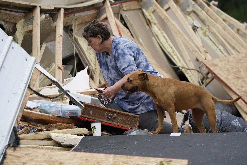 Vickie Savell looks through her belongings amid the remains of her new mobile home early Monday, May 3, 2021, in Yazoo County, Miss. Multiple tornadoes were reported across Mississippi on Sunday, causing some damage but no immediate word of injuries. (AP Photo/Rogelio V. Solis)