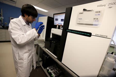 Technician Mike Lattari prepares a flow cell slide for loading onto a genetic sequencing machine at a Regeneron Pharmaceuticals Inc. laboratory at the biotechnology company's headquarters in Tarrytown, New York March 24, 2015. REUTERS/Mike Segar