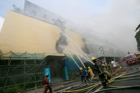 Firefighters douse water after a fire engulfed the Manila Pavilon hotel in Metro Manila, Philippines March 18, 2018. REUTERS/Romeo Ranoco