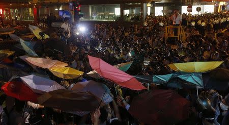 Pro-democracy protesters carrying umbrellas confront riot police at Mongkok shopping district in Hong Kong early November 29, 2014. REUTERS/Bobby Yip