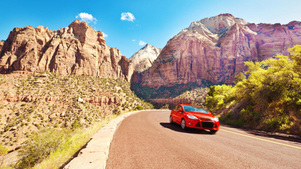 A red car vehicle touring the scenic mountain highways.