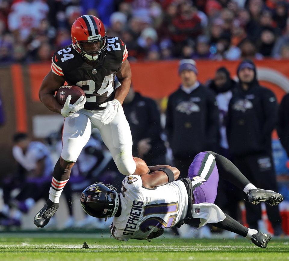Cleveland Browns running back Nick Chubb (24) rushes for yards against Baltimore Ravens free safety Brandon Stephens (21) during the first half of an NFL football game at FirstEnergy Stadium, Sunday, Dec. 12, 2021, in Cleveland, Ohio. [Jeff Lange/Beacon Journal]
