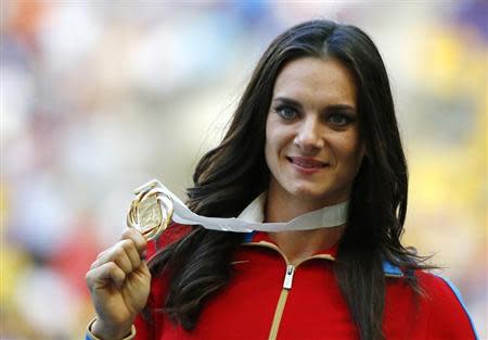 Gold medallist Yelena Isinbayeva of Russia holds her medal at the women's pole vault victory ceremony during the IAAF World Athletics Championships at the Luzhniki stadium in Moscow August 15, 2013. REUTERS/Denis Balibouse