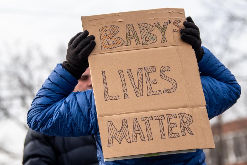 New Jersey Gov. Phil Murphy signs an abortion bill into law in front of Teaneck Library on Thursday Jan. 13, 2022. Teaneck resident Rene Rodriguez holds a sign as he protests the bill signing. Rodriguez was one of a handful of protestors at the bill signing. 