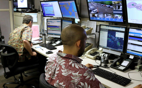 Hawaii Emergency Management Agency officials work at the department's command center in Honolulu - Credit: AP