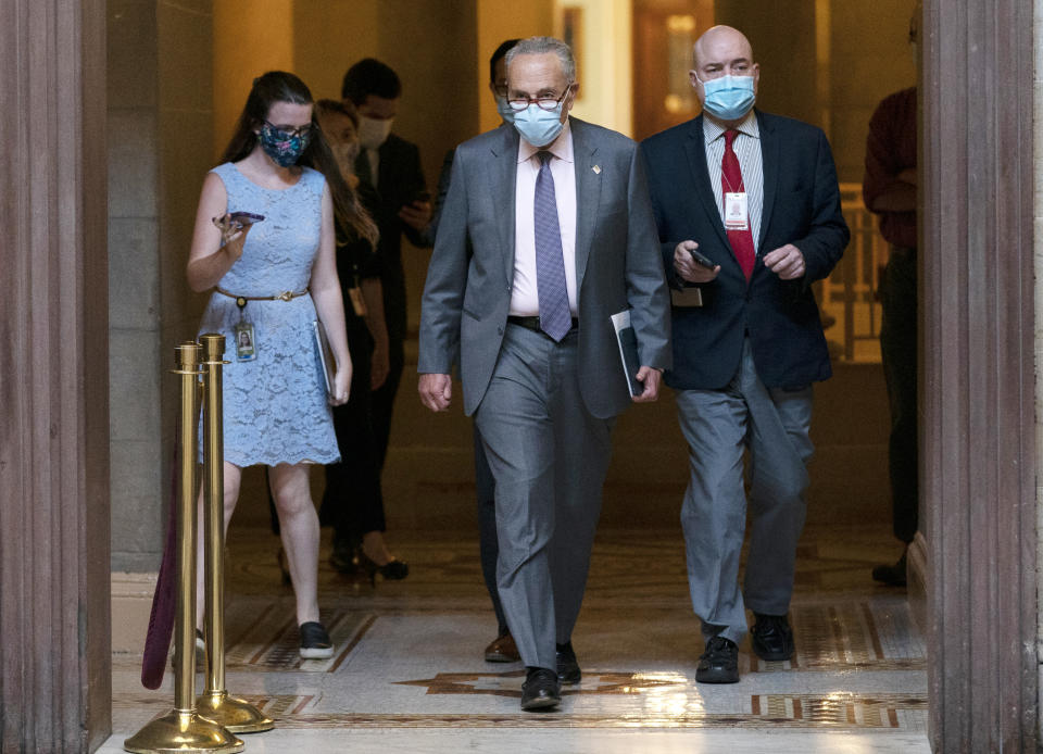 Senate Minority Leader Sen. Chuck Schumer of N.Y., center, walks to House Speaker Nancy Pelosi's office on Capitol Hill in Washington, Wednesday, Aug. 5, 2020. Some clarity is beginning to emerge from the bipartisan Washington talks on a huge COVID-19 response bill. An exchange of offers and meeting devoted to the Postal Service on Wednesday indicates the White House is moving slightly in House Speaker Nancy Pelosi's direction on issues like aid to states and local governments and unemployment insurance benefits. But the negotiations have a long ways to go. (AP Photo/Carolyn Kaster)